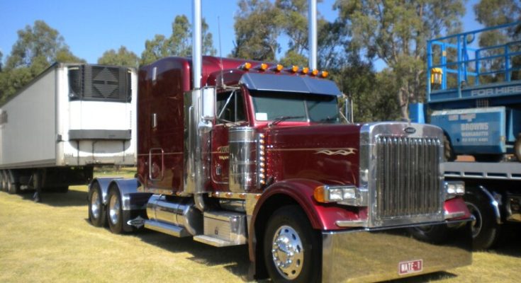 Red Peterbilt 379 with a refrigerated trailer parked outdoors