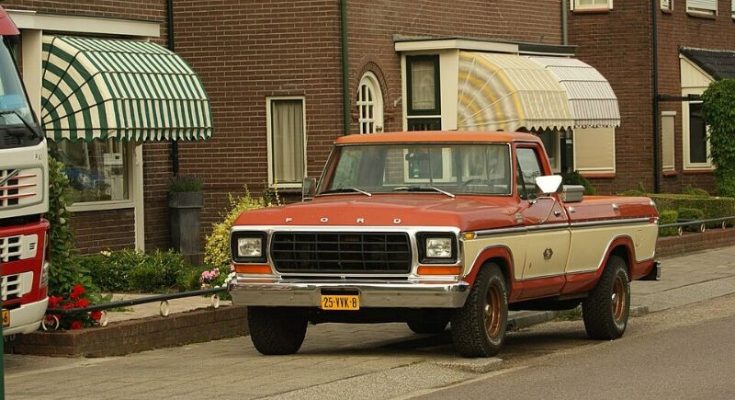 Red and cream 1978 Ford F-150 pickup parked on a residential street