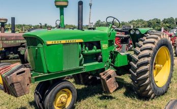 Green John Deere 4020 tractor displayed at a machinery show