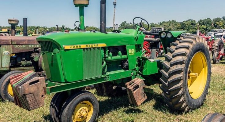 Green John Deere 4020 tractor displayed at a machinery show