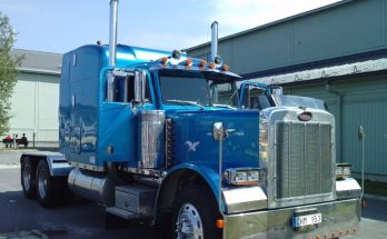 Blue Peterbilt 379 semi truck parked outside an industrial building