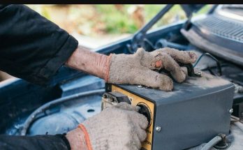 Mechanic testing a car battery under the hood