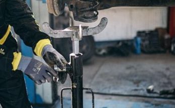Mechanic repairing a vehicle suspension inside an auto repair garage