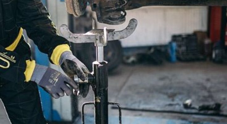 Mechanic repairing a vehicle suspension inside an auto repair garage